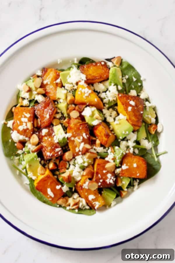Roast pumpkin, spinach, and feta salad served beautifully on a white plate