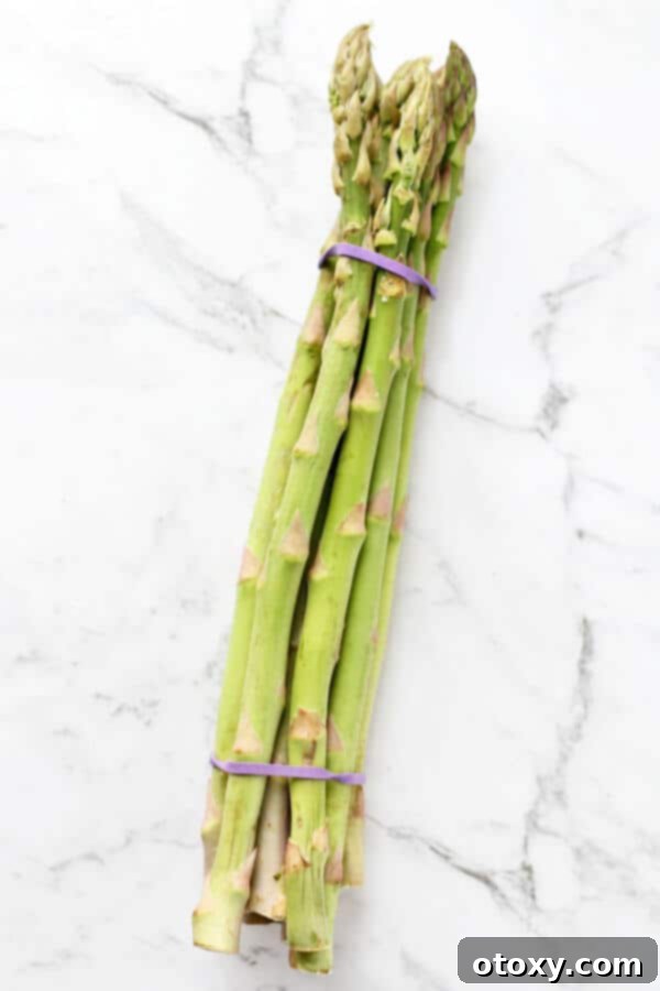 a bunch of asparagus on a white marble background