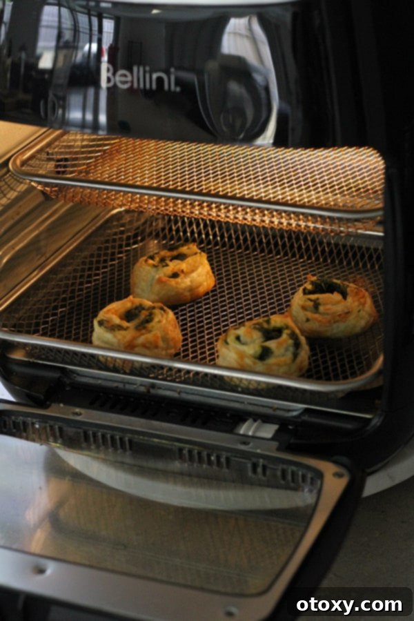 Spinach Feta Pinwheels Ready for Oven or Air Fryer 5 spinach and feta pinwheels cooking in the air fryer.