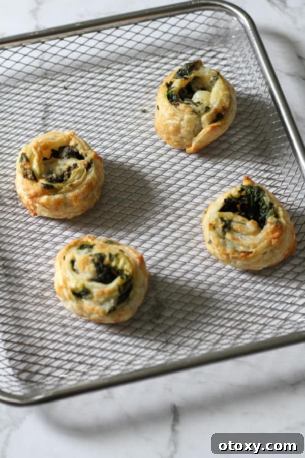 Spinach Feta Pinwheels Ready for Oven or Air Fryer 6 spinach and feta pinwheels on an air fryer tray.