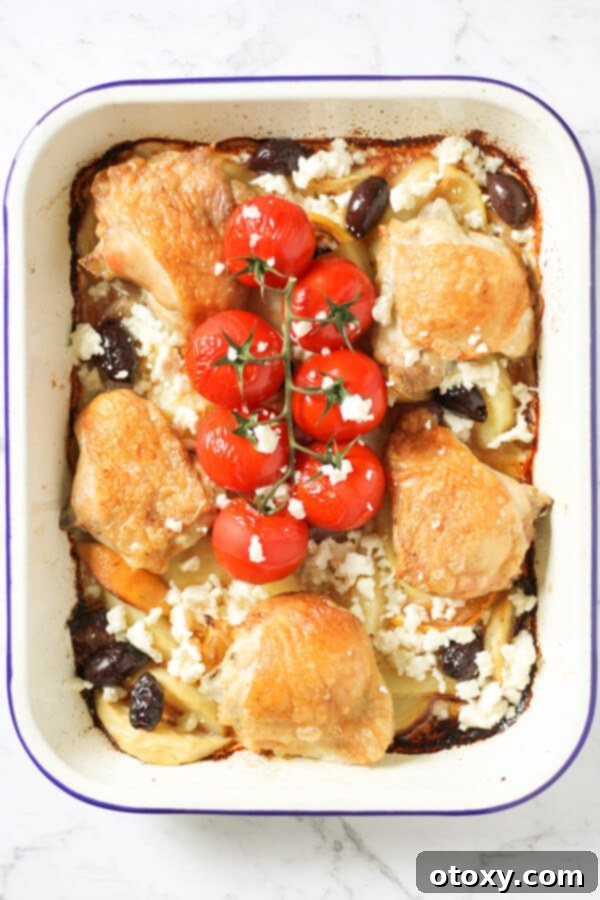 A vibrant close-up of the finished Sheet Pan Greek Chicken and Potatoes, showcasing the golden-brown chicken skin, tender potatoes, and colorful vegetables.