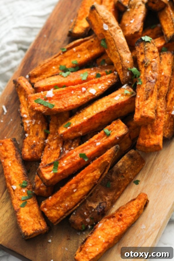 Crispy Air Fryer Sweet Potato Wedges seasoned with salt, served in a rustic wooden bowl.
