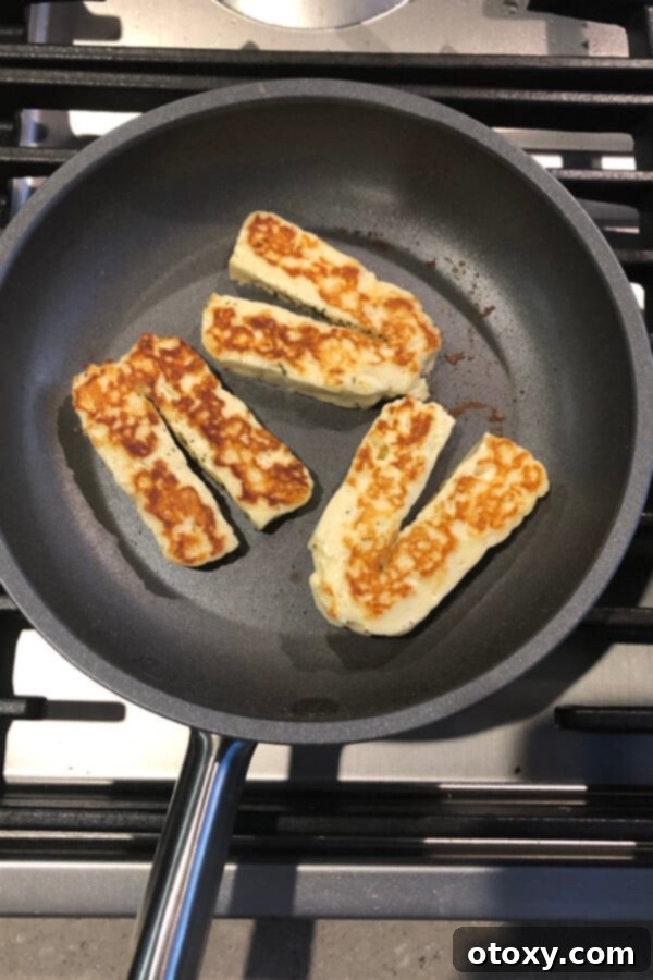 cooked halloumi slices in a skillet.