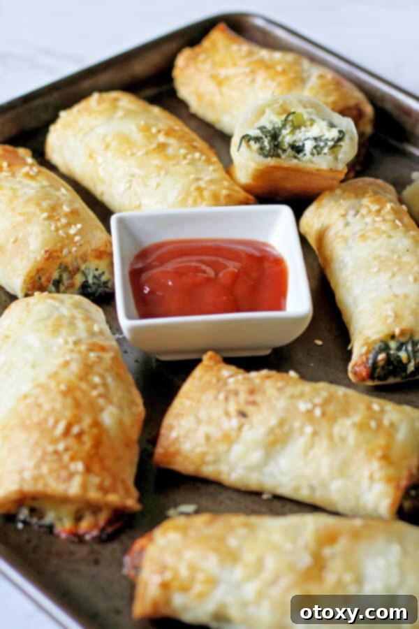 Spinach Ricotta Rolls Oven or Air Fried 13 A fresh batch of baked spinach and ricotta rolls on a baking tray, showcasing their golden crust and enticing aroma.