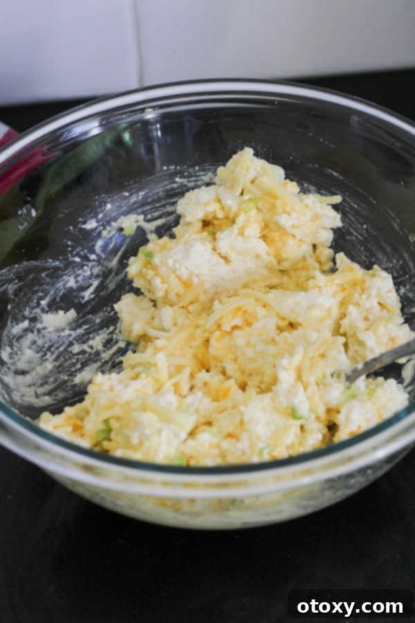 Spinach Ricotta Rolls Oven or Air Fried 6 A bowl filled with a creamy mixture of ricotta, Parmesan, and cheddar cheese, waiting for the spinach to be added.