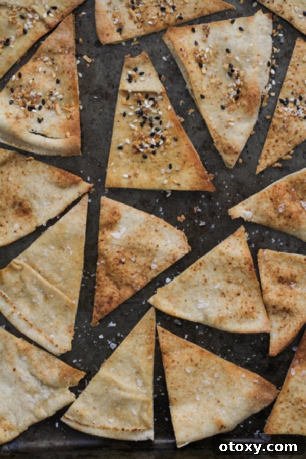 baked pita chips on a baking tray. A close-up view of golden-brown, perfectly baked pita chips resting on a baking tray after being removed from the oven.