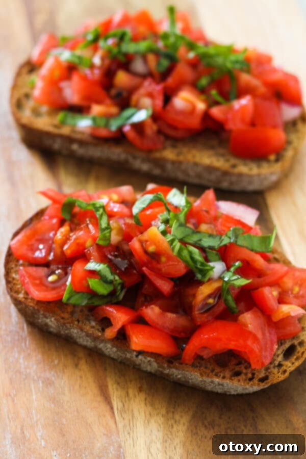 Effortless Bruschetta 5 Two pieces of bruschetta artfully arranged on a rustic wooden board, generously drizzled with balsamic glaze, ready for a gathering.