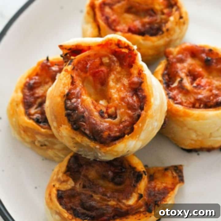 Pinwheels on a white plate with fresh basil garnish.