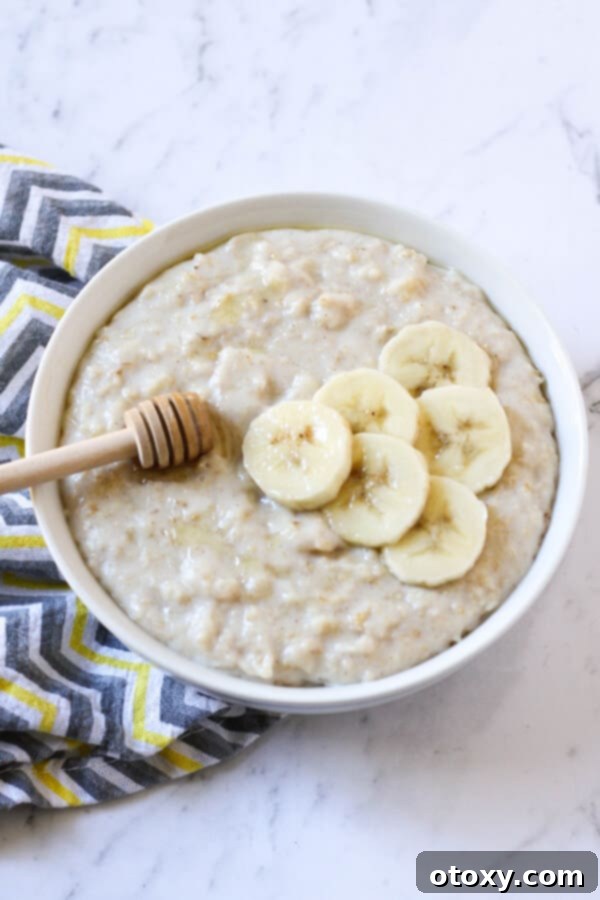 Crafting the Perfect Bowl of Oats 4 A bowl of wholesome oatmeal, topped with fresh banana slices and a delicate drizzle of golden honey, perfect for a nourishing and naturally sweet start to the day.