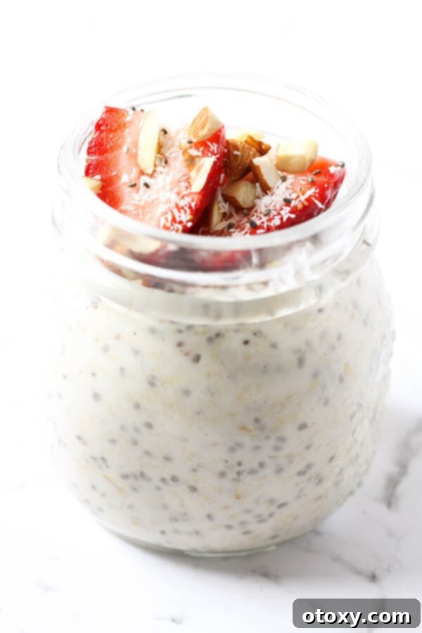 Nutritious Overnight Oats 4 Overhead view of a beautiful glass jar of healthy overnight oats, generously topped with fresh berries, crunchy almonds, and delicate shredded coconut, ready to be enjoyed.