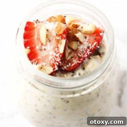 Nutritious Overnight Oats 7 Jar of vibrant overnight oats topped with fresh strawberries, shredded coconut, and sliced almonds.