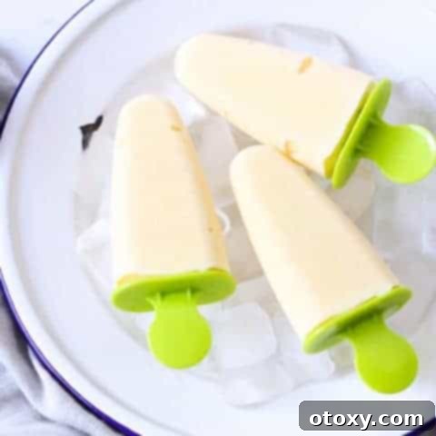 Deliciously creamy homemade mango popsicles, garnished and ready to serve.