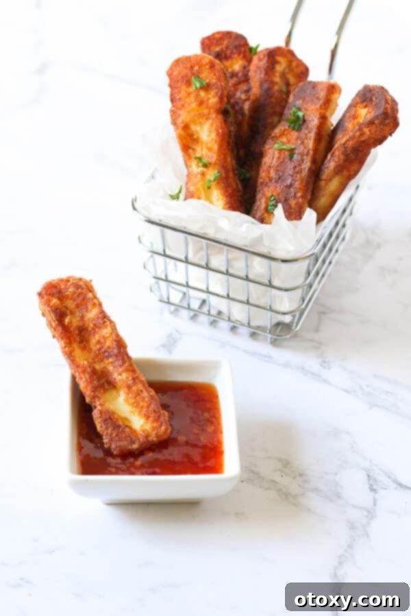 A generous serving of crispy halloumi fries nestled in a wire basket, ready to be enjoyed.