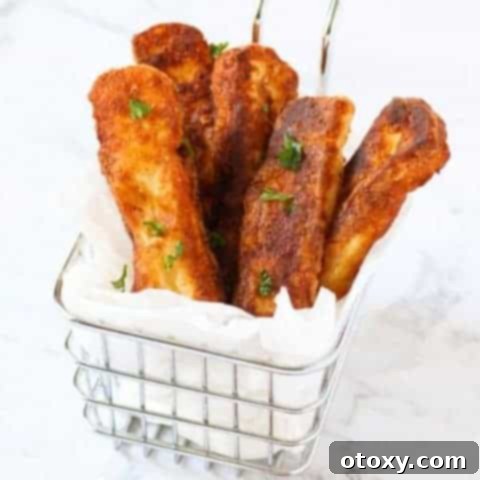 Crispy halloumi fries presented in a wire basket, ready to be served.