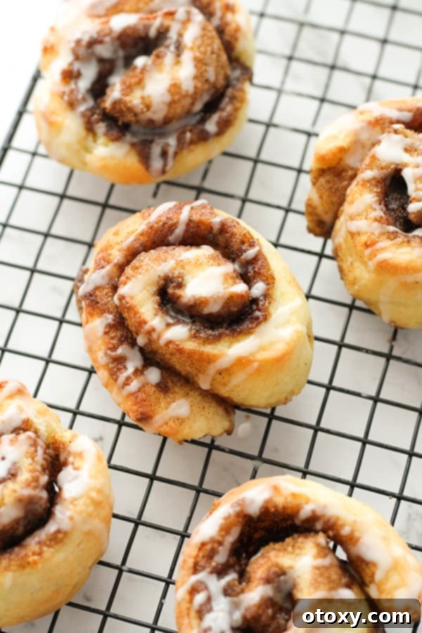 Warm, glazed no-yeast cinnamon rolls arranged on a wire cooling rack, ready to be devoured.