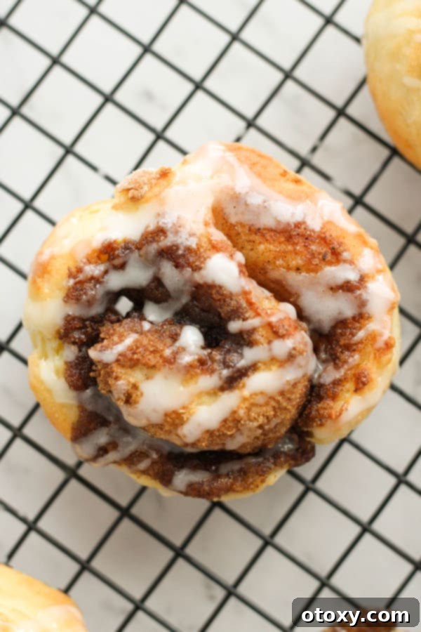 A single glazed no-yeast cinnamon roll presented on a wire cooling rack, perfect for a treat.