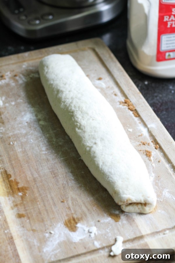 The two-ingredient dough rolled into a tight log on a wooden cutting board.