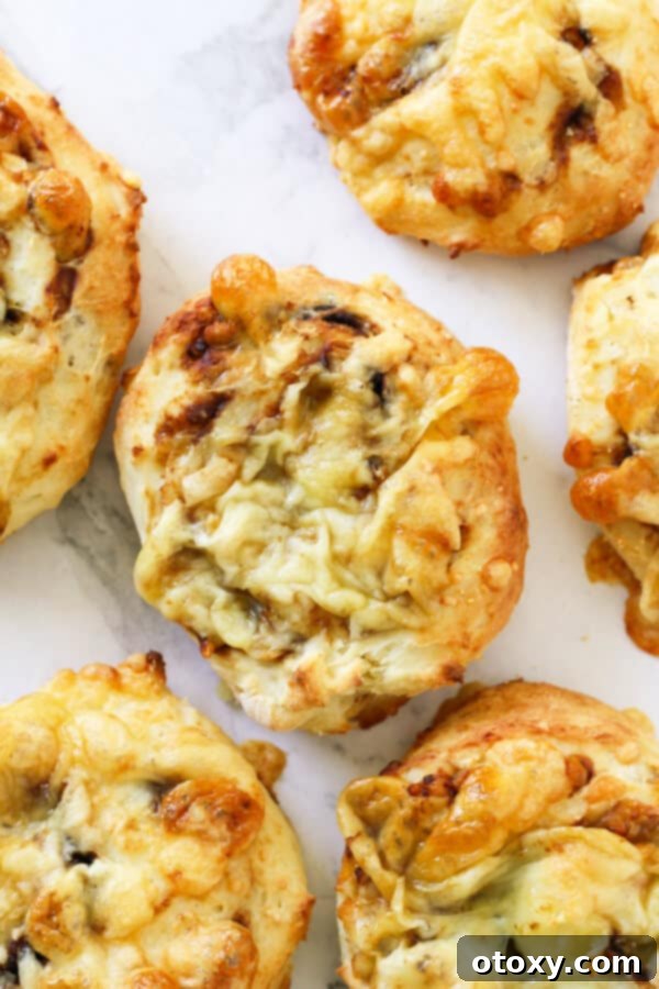 Vegemite Cheese Pinwheels 2 cheese and vegemite scrolls lying on a marble board.