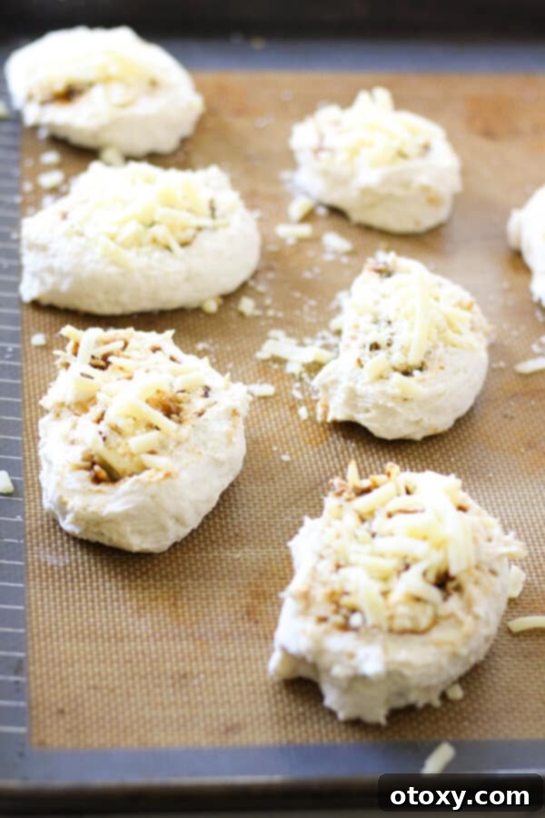 Vegemite Cheese Pinwheels 7 cheese and vegemite scrolls on a baking tray ready for the oven.