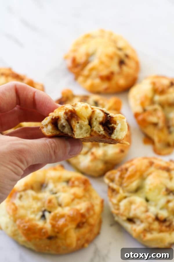 Vegemite Cheese Pinwheels 9 cheese and vegemite scrolls lying on a marble board.