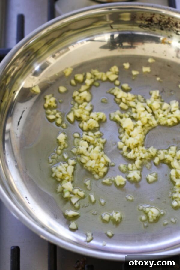 Classic Garlic and Olive Oil Spaghetti 5 garlic sautéing in a frying pan.
