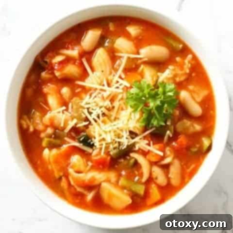 A comforting bowl of Minestrone Soup with a spoon, ready to be enjoyed as a hearty meal.