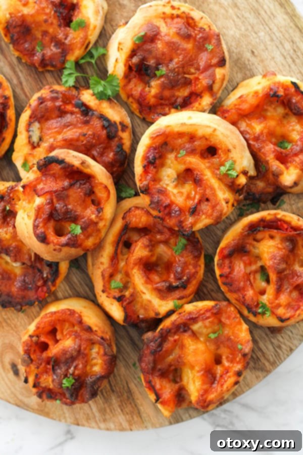 Pizza Pinwheels 2 pizza scrolls on a wooden board.