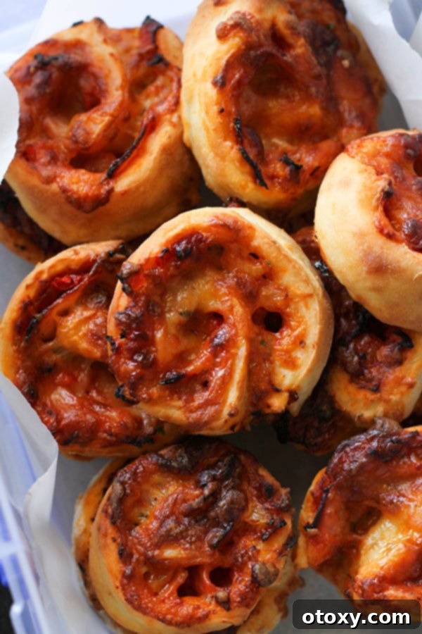 Pizza Pinwheels 11 pizza scrolls piled on top of each other in a container.