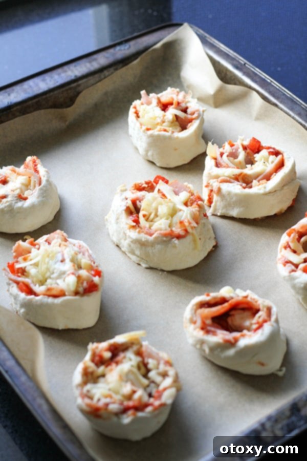 Pizza Pinwheels 9 Pizza scrolls on a baking tray ready for the oven.