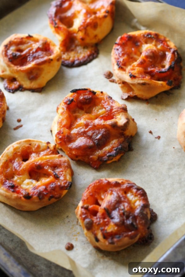 Pizza Pinwheels 10 pizza scrolls on a baking tray.