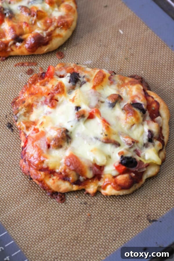 Freshly baked supreme pizza on a baking tray, hot out of the oven.