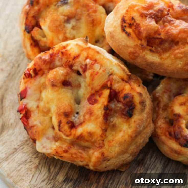 Delicious bakery-style vegetarian pizza rolls, golden brown and filled with cheesy goodness, made effortlessly with two-ingredient dough.