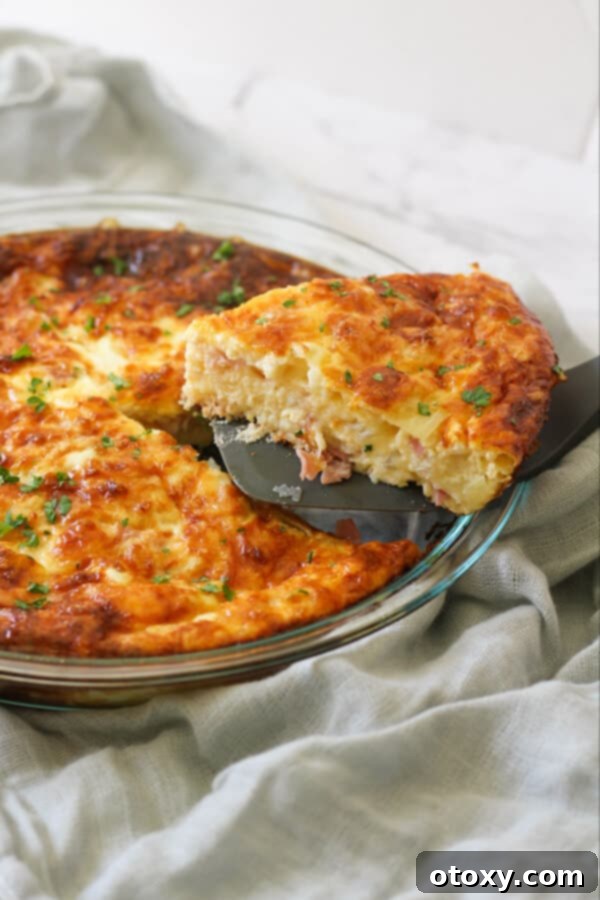 Golden brown Impossible Quiche in a classic glass pie dish, beautifully baked and ready to be served.