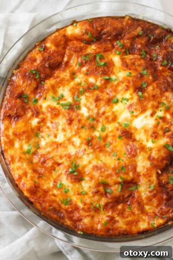 Close-up view of a perfectly cooked Impossible Quiche, golden brown and inviting, in a glass pie dish.