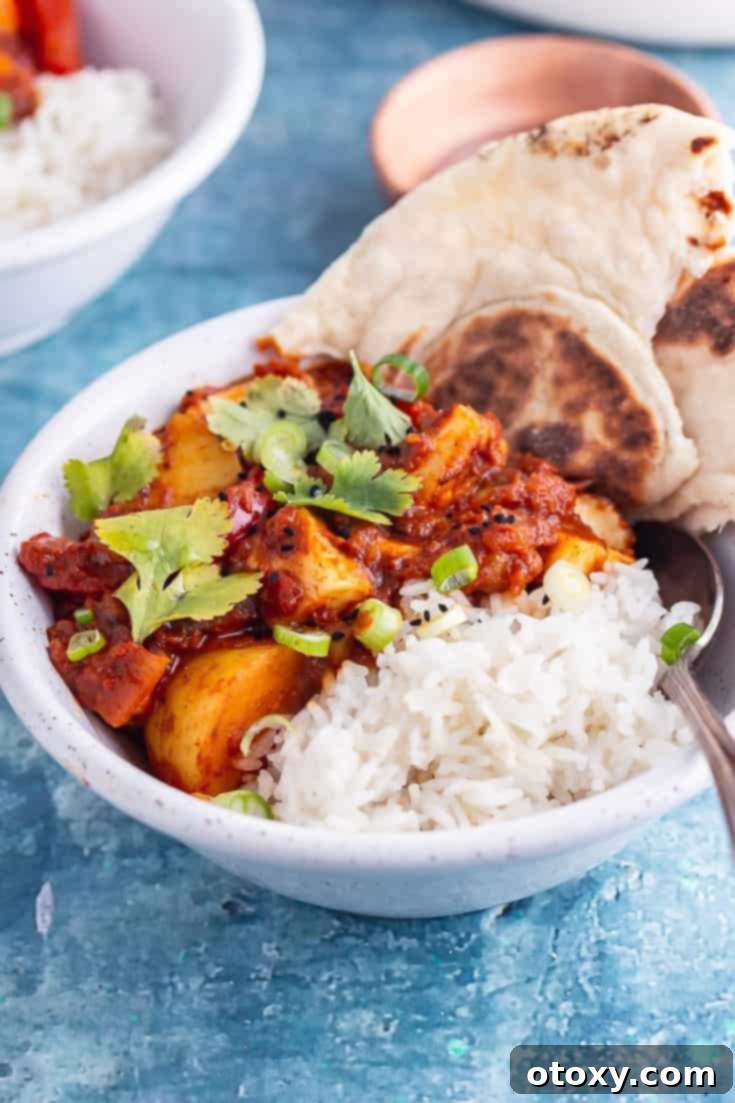 A hearty bowl of Spicy Halloumi Curry with Potato, served with rice.