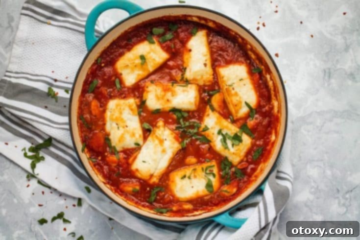 A vibrant Halloumi and White Bean Bake in a rich tomato sauce, served in a skillet.