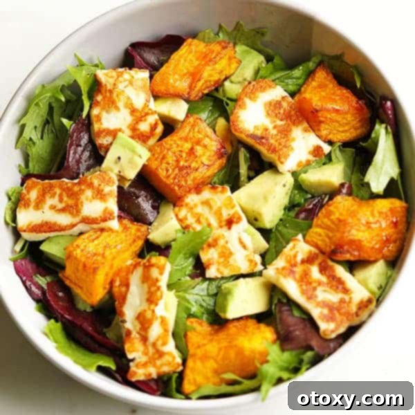 A vibrant Pumpkin, Halloumi, and Avocado Salad in a bowl.