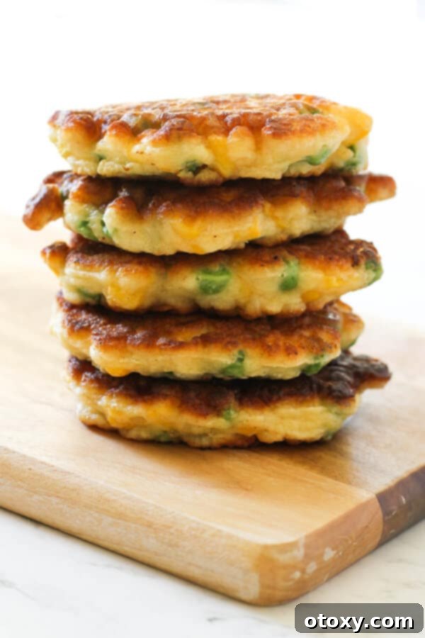 Vibrant Pea and Sweet Corn Fritters 2 Delicious and healthy Pea & Sweet Corn Fritters stacked on a rustic wooden board, ready to be served.