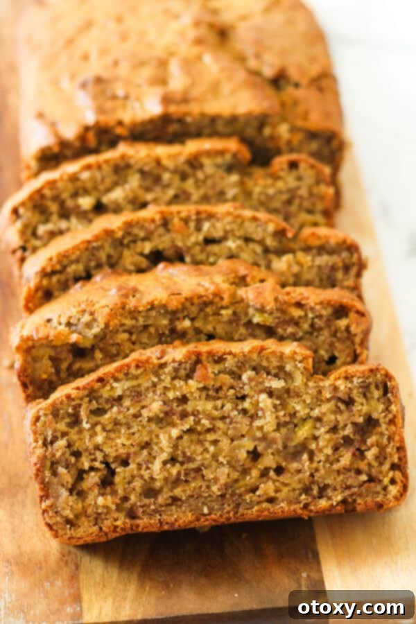 Velvety Buttermilk Banana Bread 2 Perfectly sliced Buttermilk Banana Bread, rich and moist, displayed on a rustic wooden cutting board, ready to be enjoyed.
