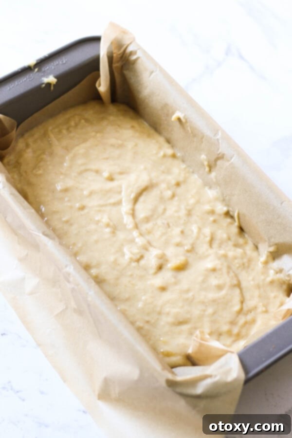 Velvety Buttermilk Banana Bread 8 Smooth and perfectly mixed Buttermilk Banana Bread batter poured into a parchment-lined loaf pan, ready for baking.