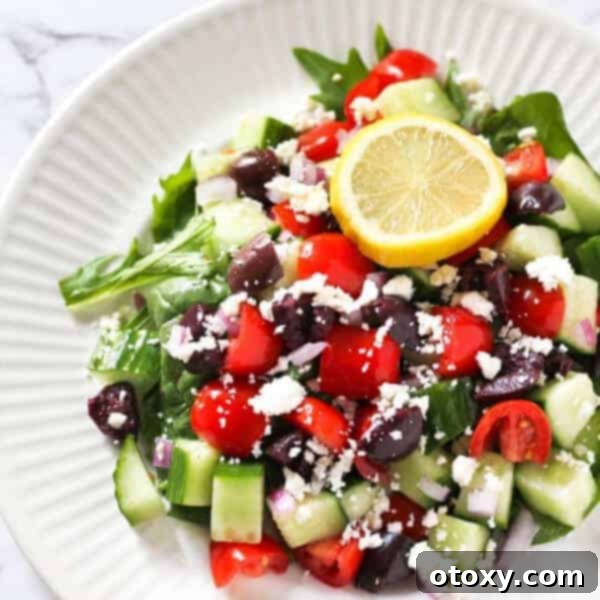 A vibrant and refreshing Easy Greek Salad, brimming with fresh vegetables, Kalamata olives, and generous chunks of feta cheese, drizzled with a light vinaigrette.