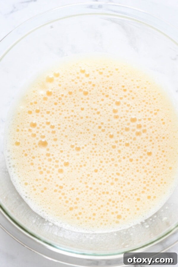 Zesty Orange Almond Tea Cakes 7 Step by step photo instructions showing eggs and sugar being beaten in a bowl until light and fluffy.