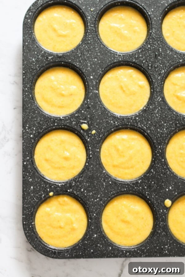 Zesty Orange Almond Tea Cakes 8 Step by step photo instructions showing raw batter being spooned into muffin trays.