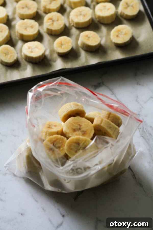 Freshly sliced banana rounds neatly stored in a clear freezer-safe ziplock bag, ready for long-term storage and use in smoothies or baking.