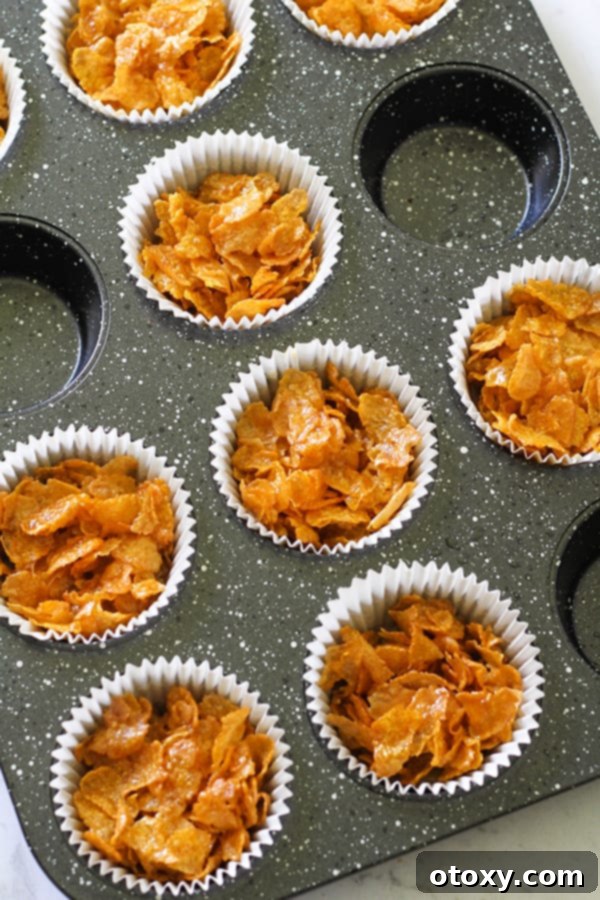 Honey joys in white paper liners in a muffin tin.