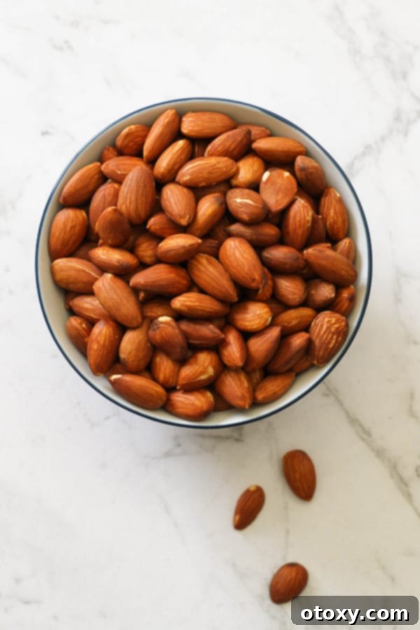 A small, elegant bowl filled with perfectly dry roasted almonds, presented against a clean backdrop to emphasize their appealing color and texture.