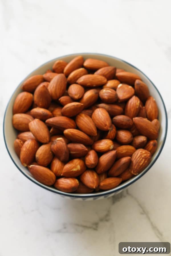 A small, inviting bowl filled with dry roasted almonds, demonstrating their perfect toastiness and readiness for enjoyment.