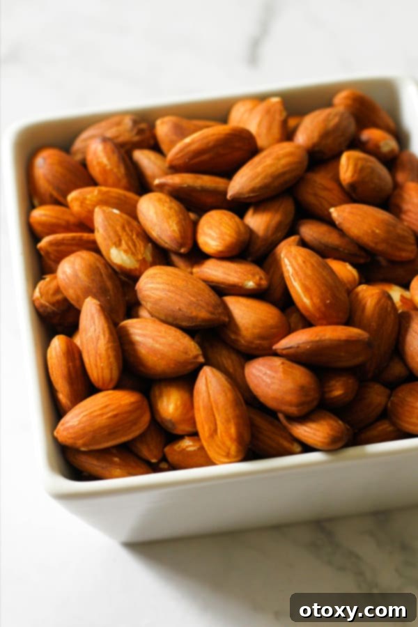 Golden Roast Almonds 2 Roasted almonds in a white square serving bowl.