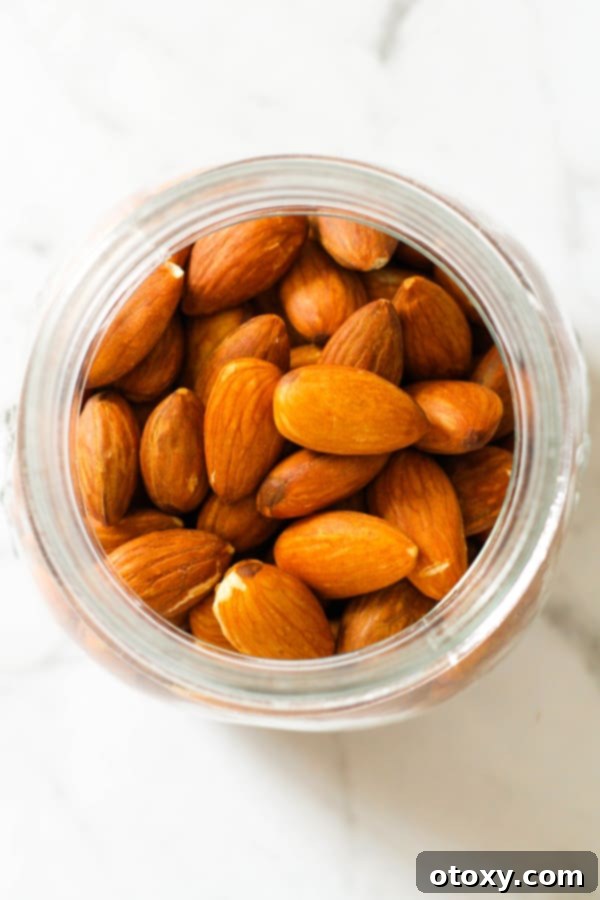Golden Roast Almonds 3 roasted almonds in a glass jar.