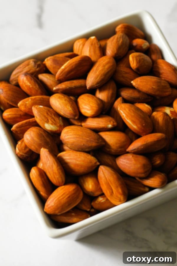Golden Roast Almonds 6 Roasted almonds in a white square serving bowl.